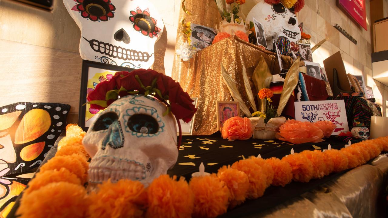 "Ofrenda" commemorating Dia de Los Muertos at Mondavi Center with skeleton mask, orange decorations