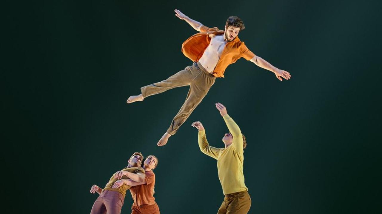 Dancers flying through the air against black backdrop