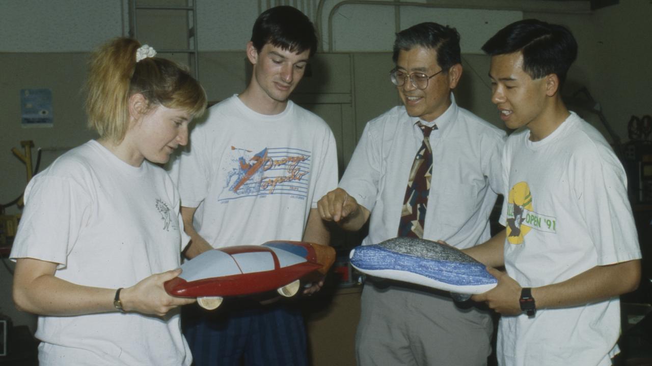 Professor Andrew Frank and three students look at small model cars in 1992 photo.