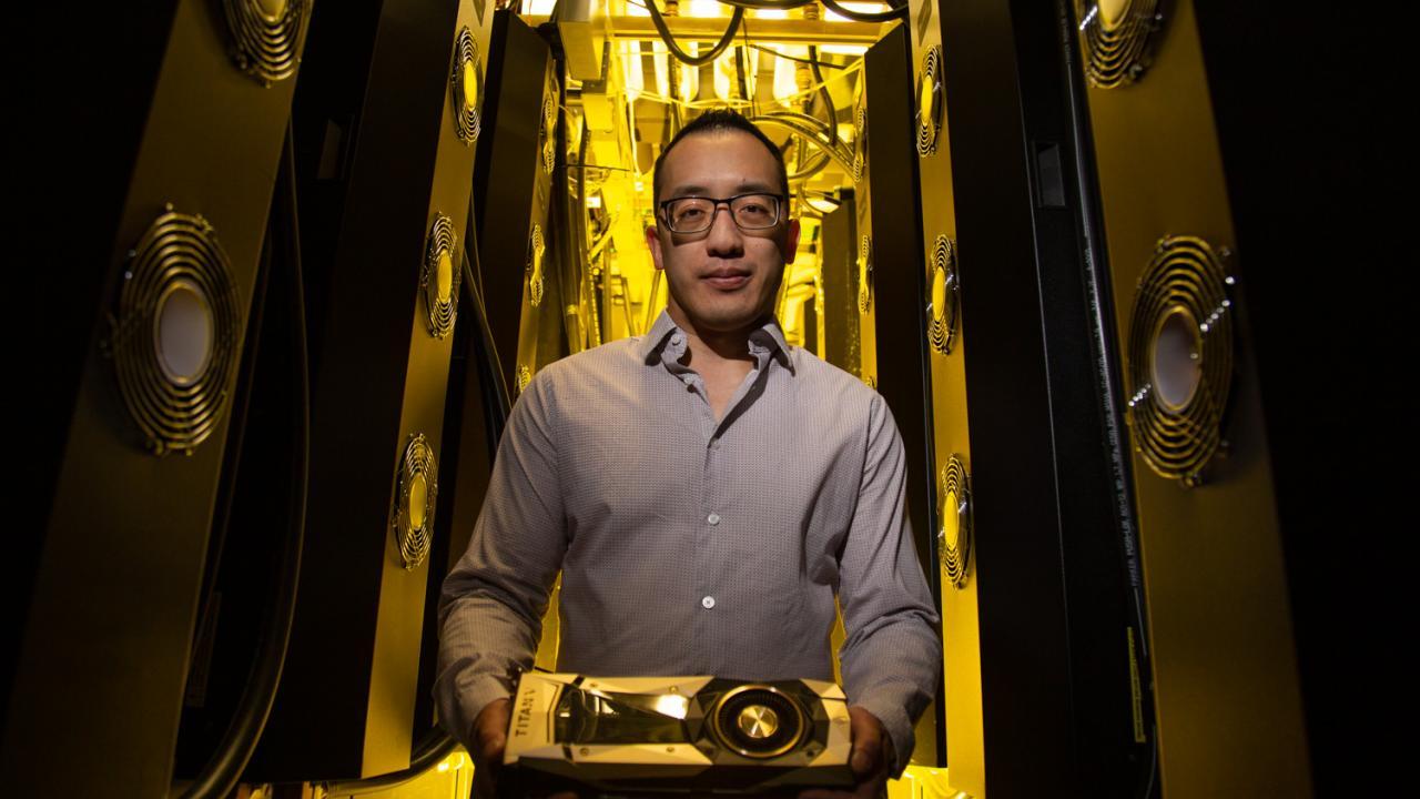 Male scientist holding NVIDIA Titan V graphics card 