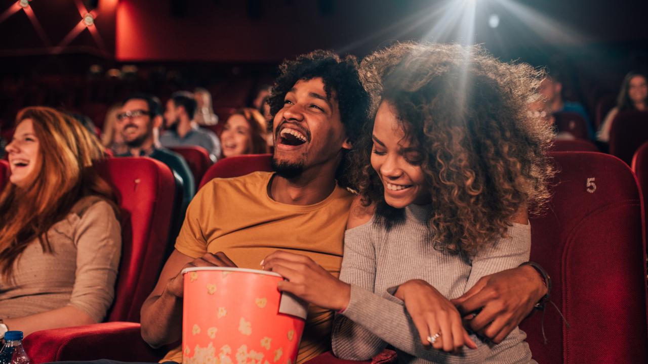 Young adults of various ethnicities watching a movie in a theater