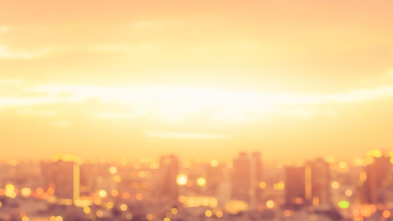 A city skyline behind an orange heat wave haze.