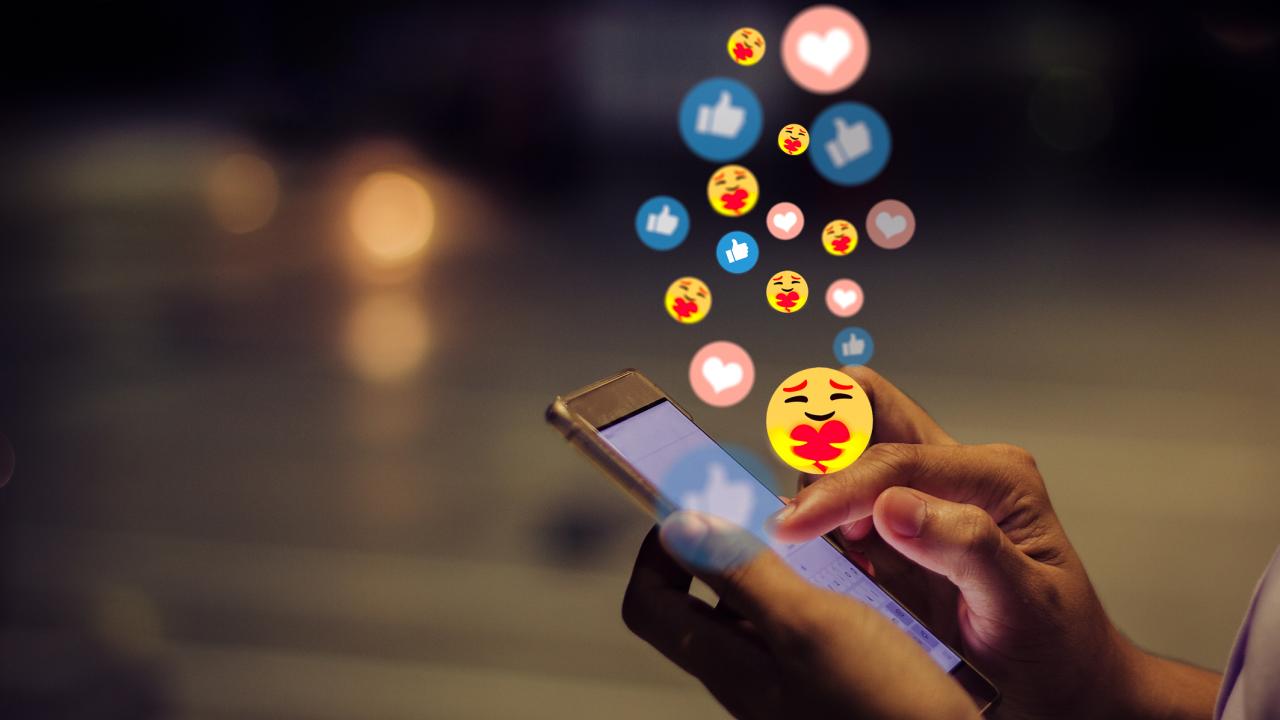 Person's hands holding phone showing social media icons