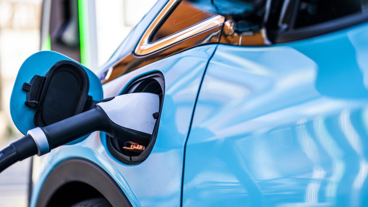 Blue electric vehicle being charged