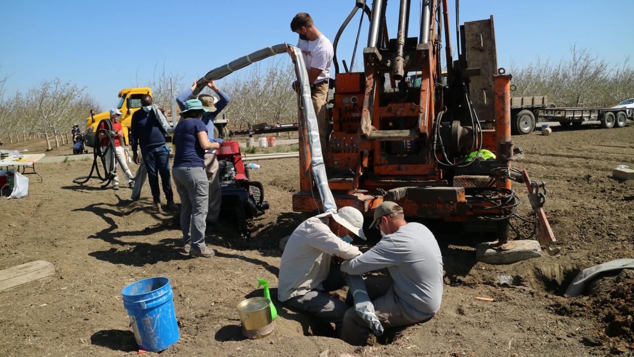 UC Davis researchers insert a long tunnel-like device into the ground of a unplanted farm field. The device continuously collects water samples underground, providing real-time data on nitrate contaminant movement. (Isaya Kisekka / UC Davis)