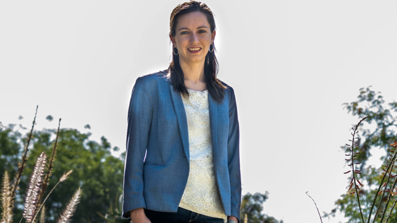 Female scientist standing outdoors in blue jacket