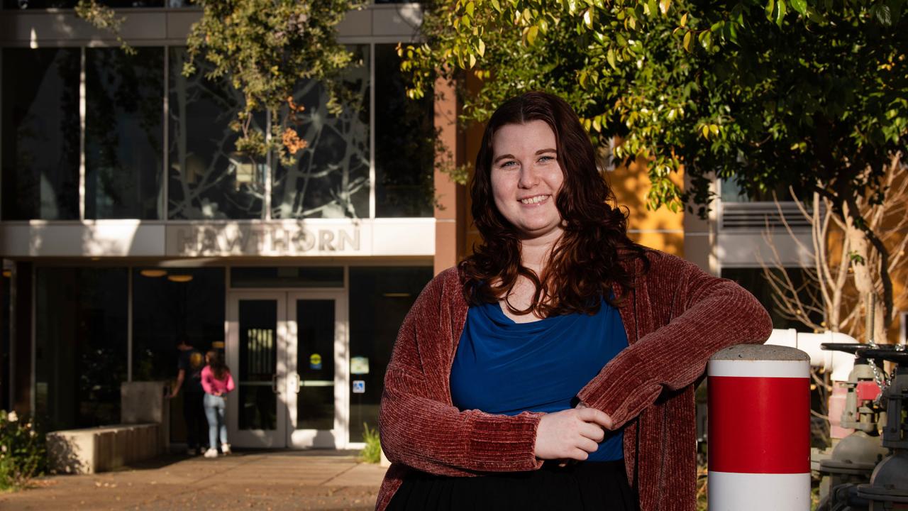 Kaitlin "Kat" Raymond stands in front of Hawthorn Hall
