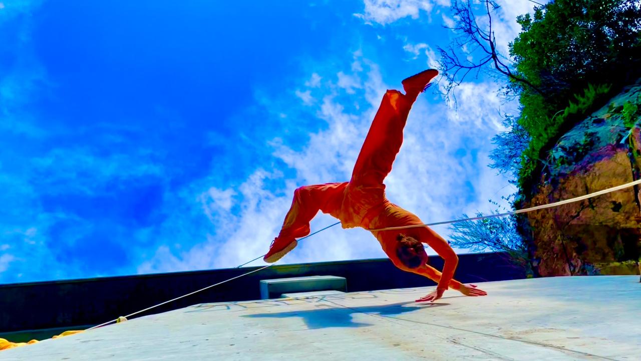 Woman doing dance routine with blue sky in background