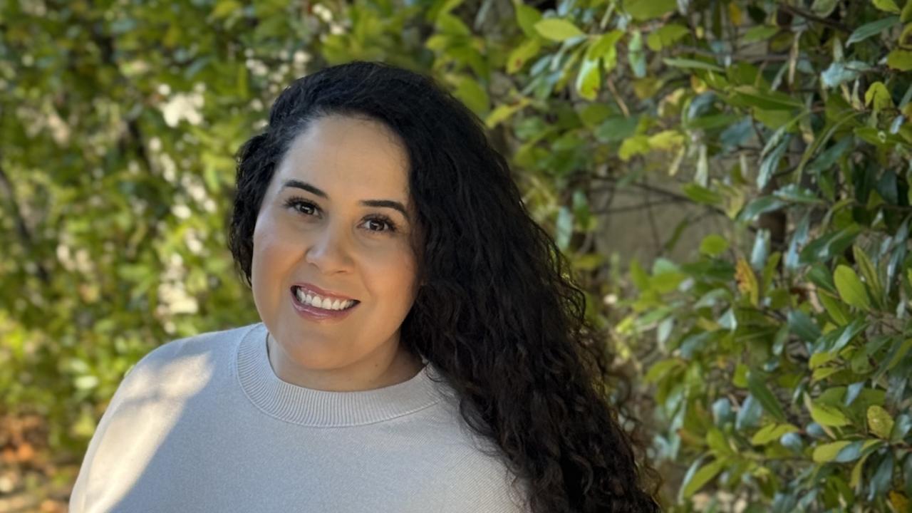 A closeup of Lizbeth Lopez with greenery in the background