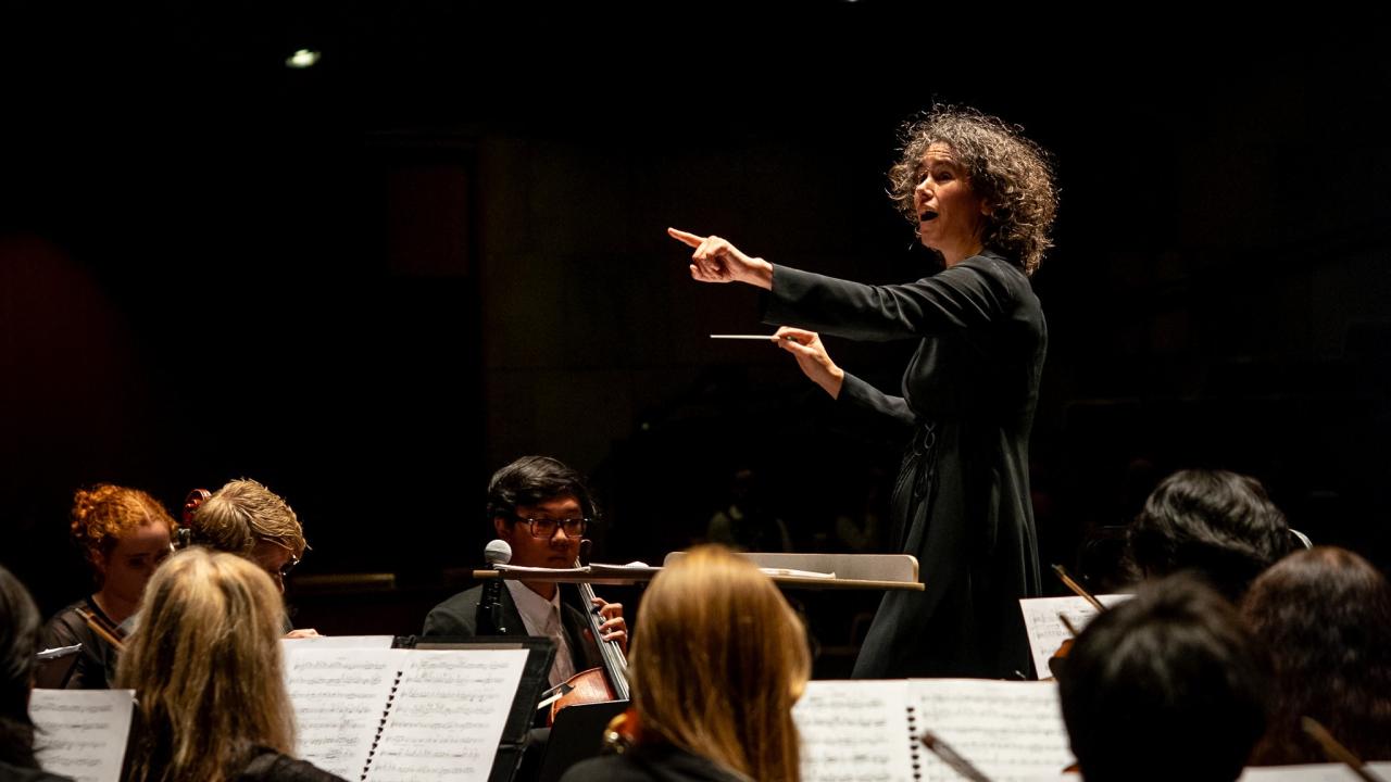 Symphony being directed by a woman on stage 