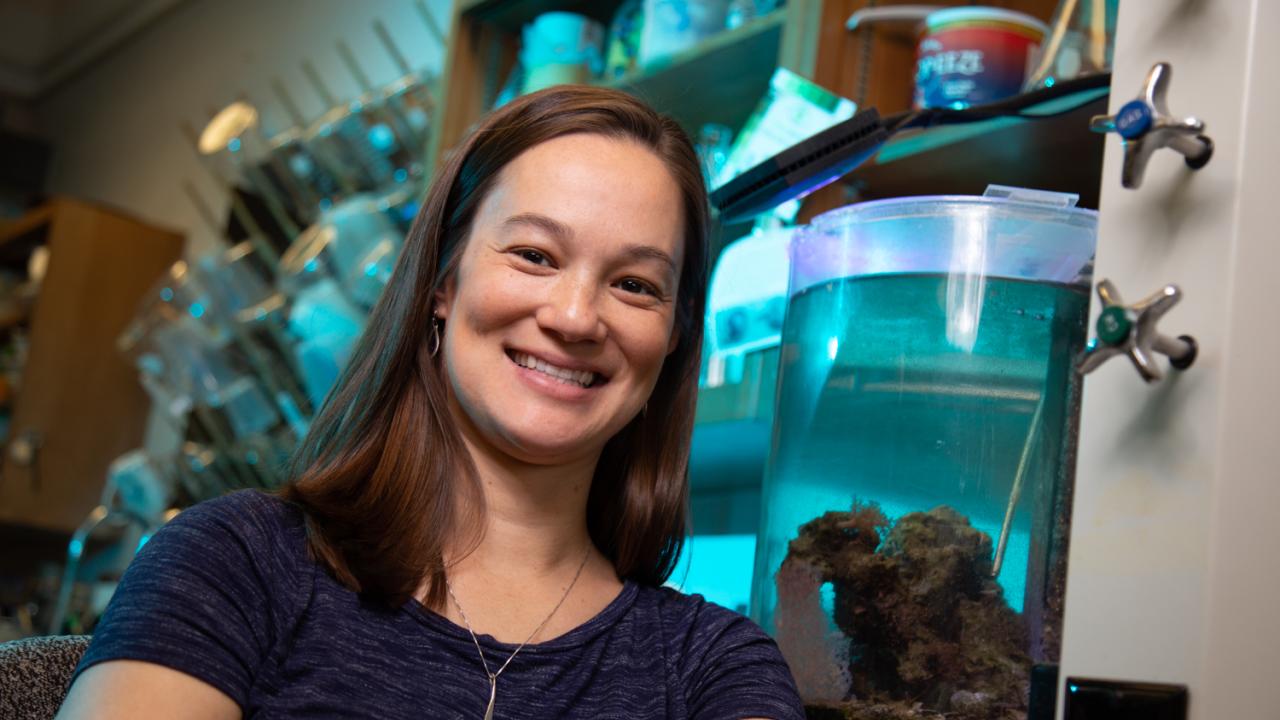 Female scientist in lab in front of water tanks