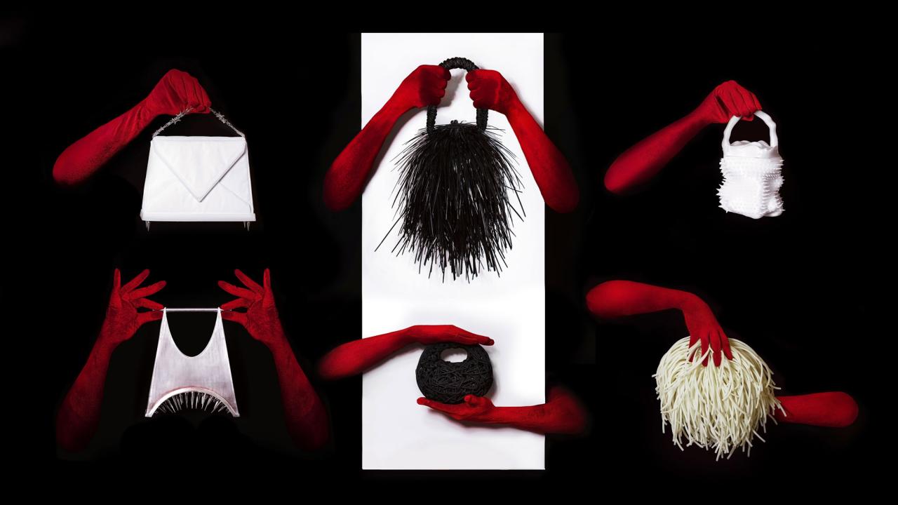 Red-gloved hands hold assorted wigs and masks on white panels against black background