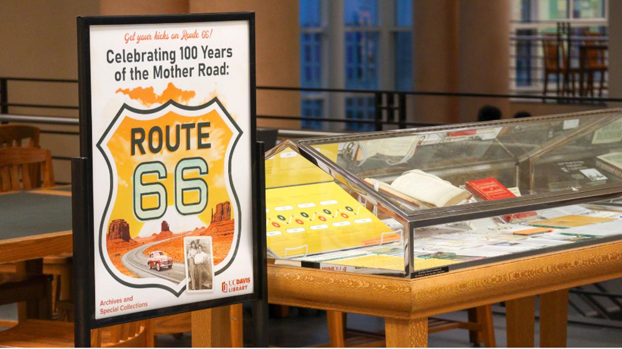 Museum Route 66 exhibit with tall sign and lit glass display cases