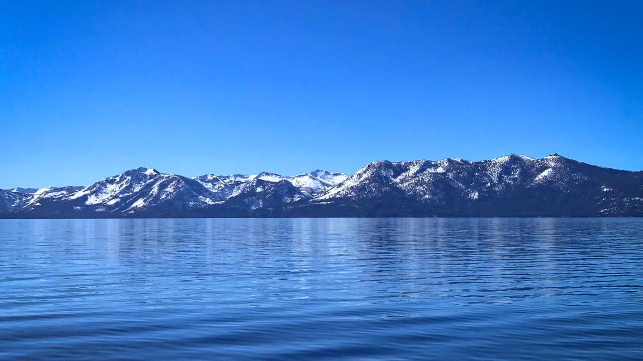 Lake Tahoe's surface in winter with snow-dusted mountains in background
