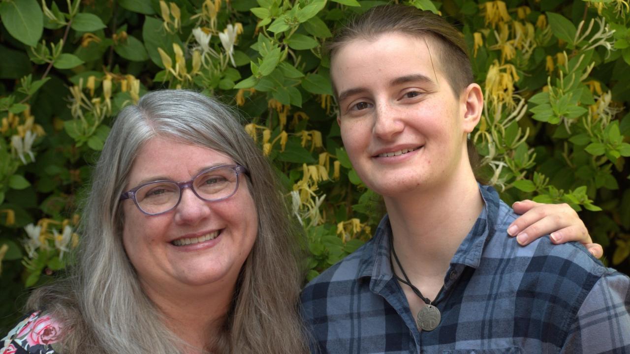 Teresa and Anna Skarr pose together in front of a bush at UC Davis. 