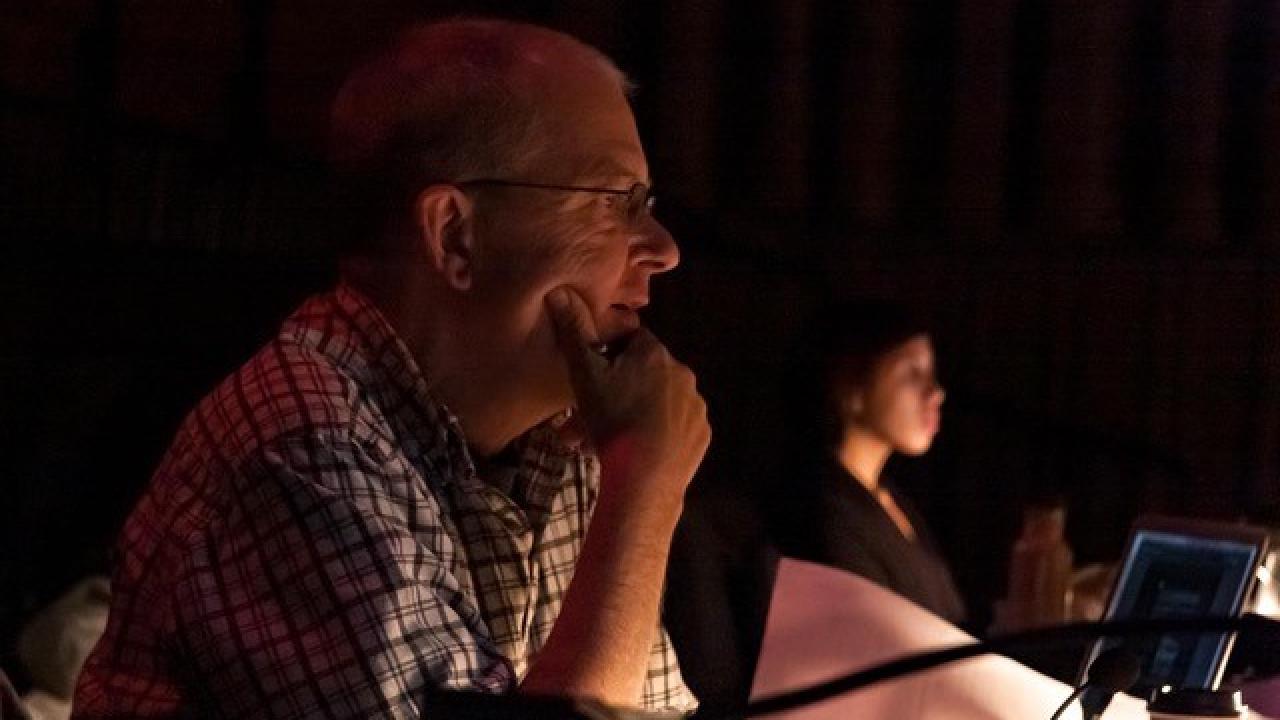 Tom Munn sitting at a desk at technical rehearsal for Tilly NoBody