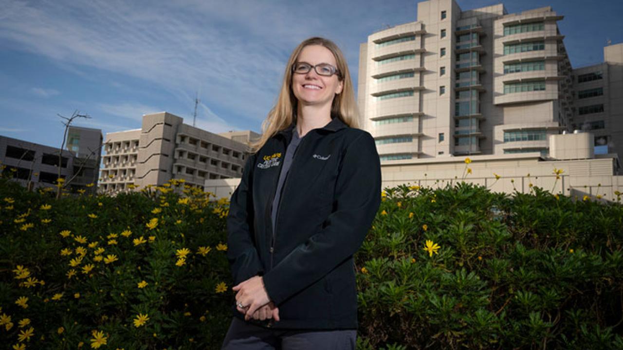 Female scientist outdoors in front of UC Davis Medical Center