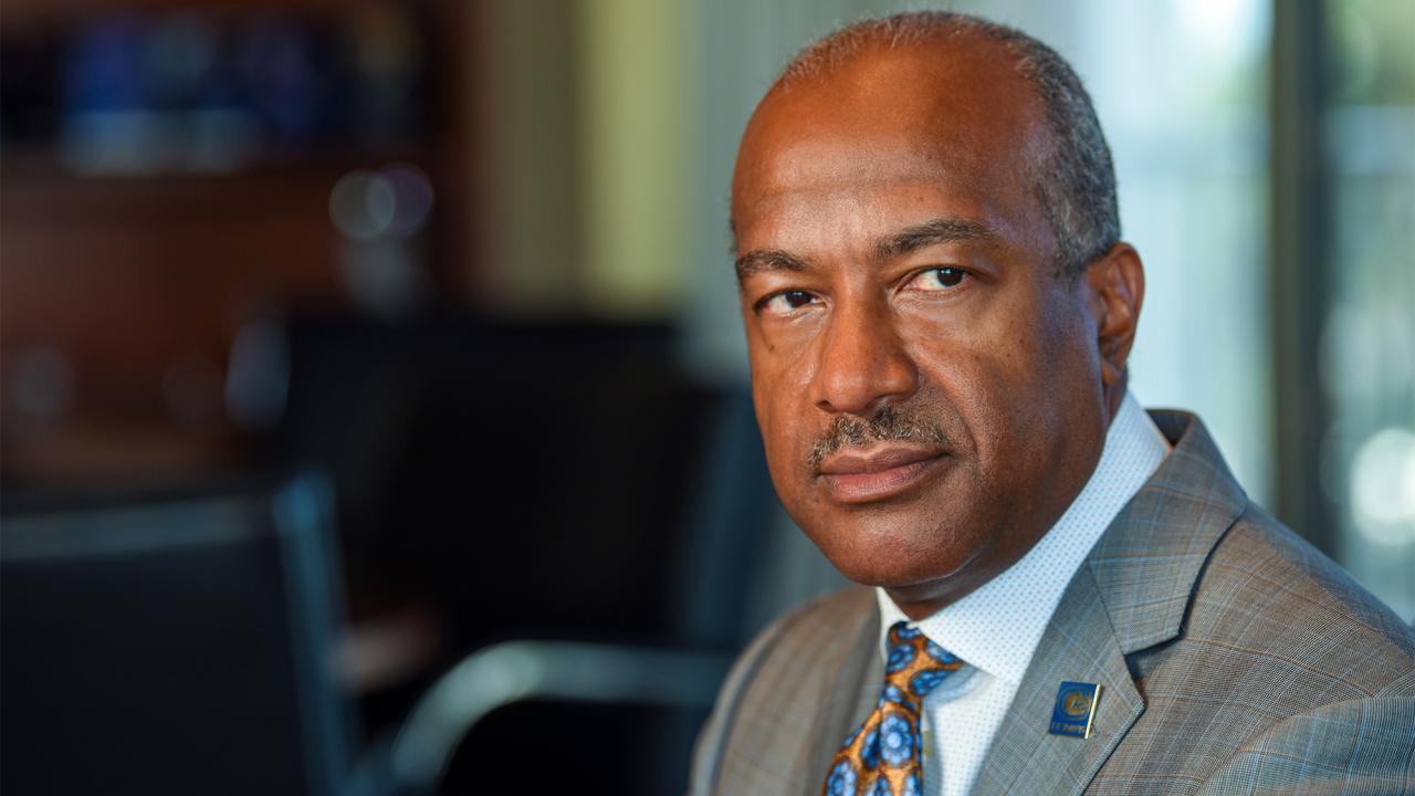 Chancellor Gary S. May has a somber look while sitting at his desk.