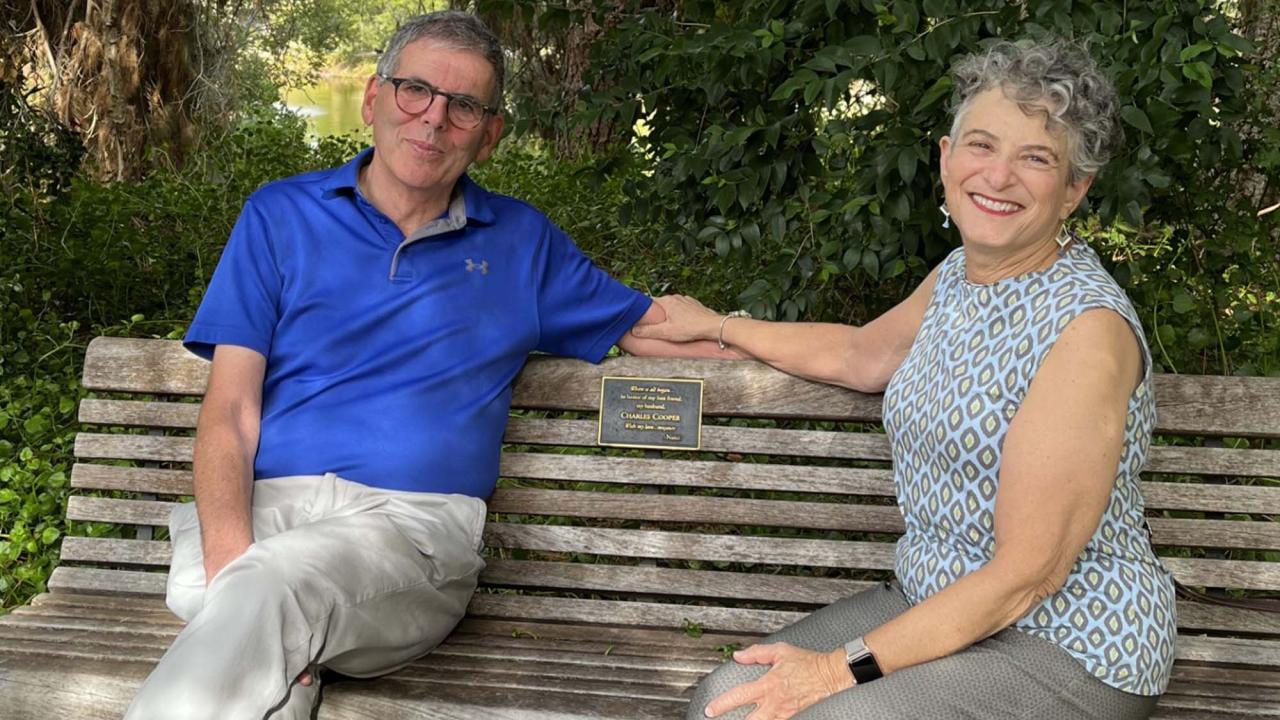 Chuck and Nancy Cooper sit on wood bench