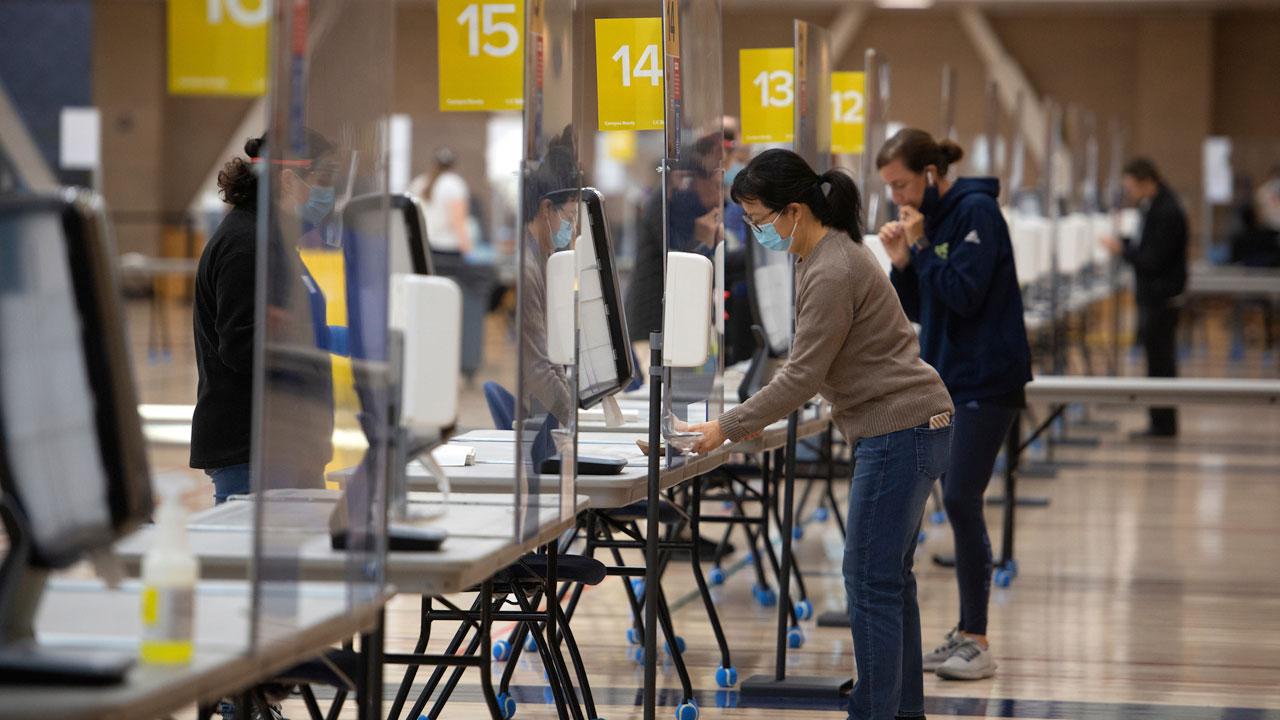 Several people line up to get tested at a UC Davis campus COVID testing site