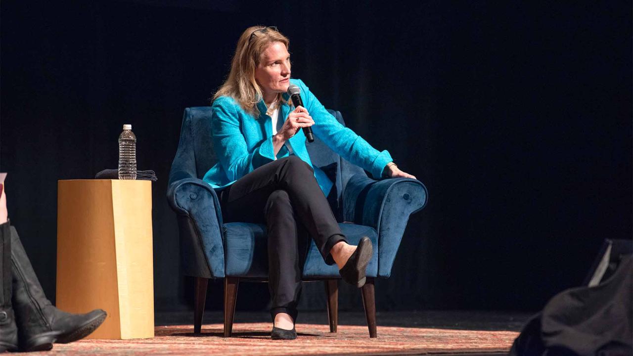 Cynthia Miller-Idriss sits in chair on stage, speaking