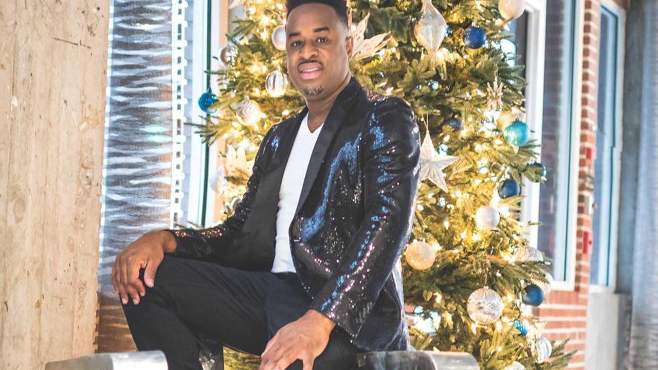 Black man in suit in front of gold background