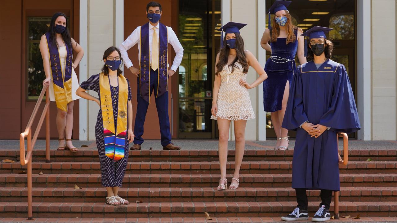 Students in grad caps and face coverings pose for a photo.