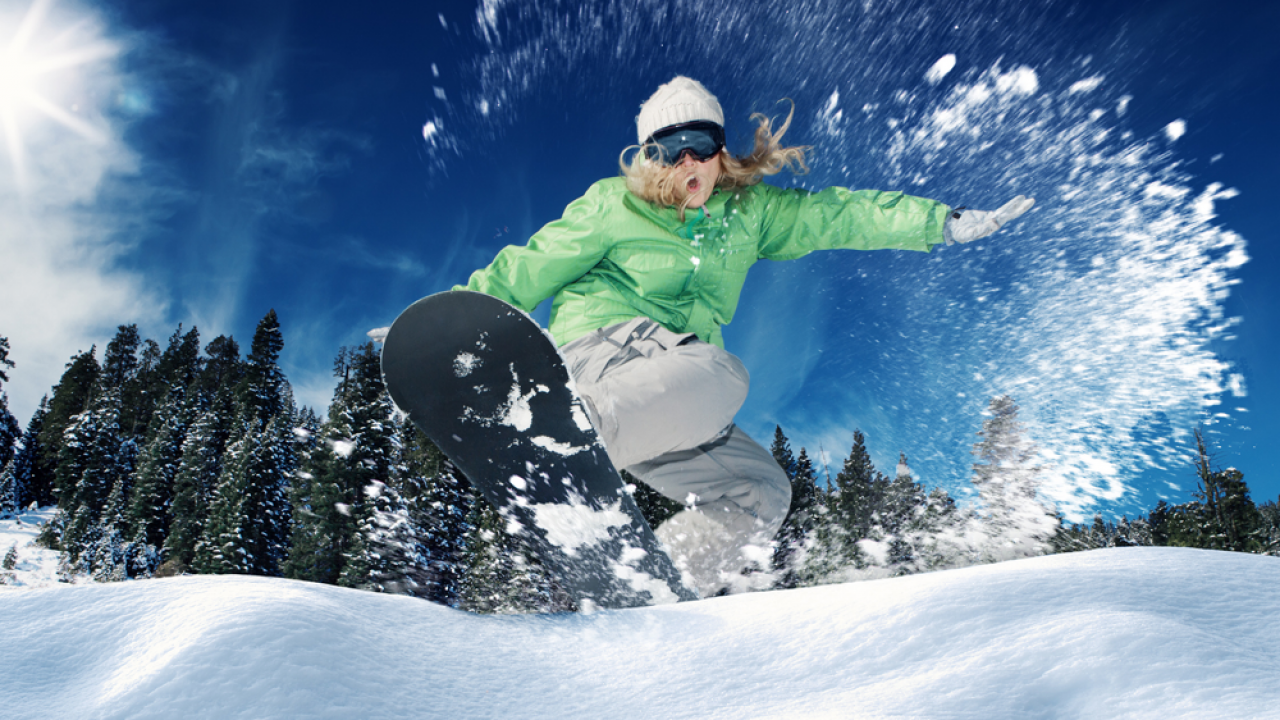 A female snowboarder carves up a Tahoe mountain