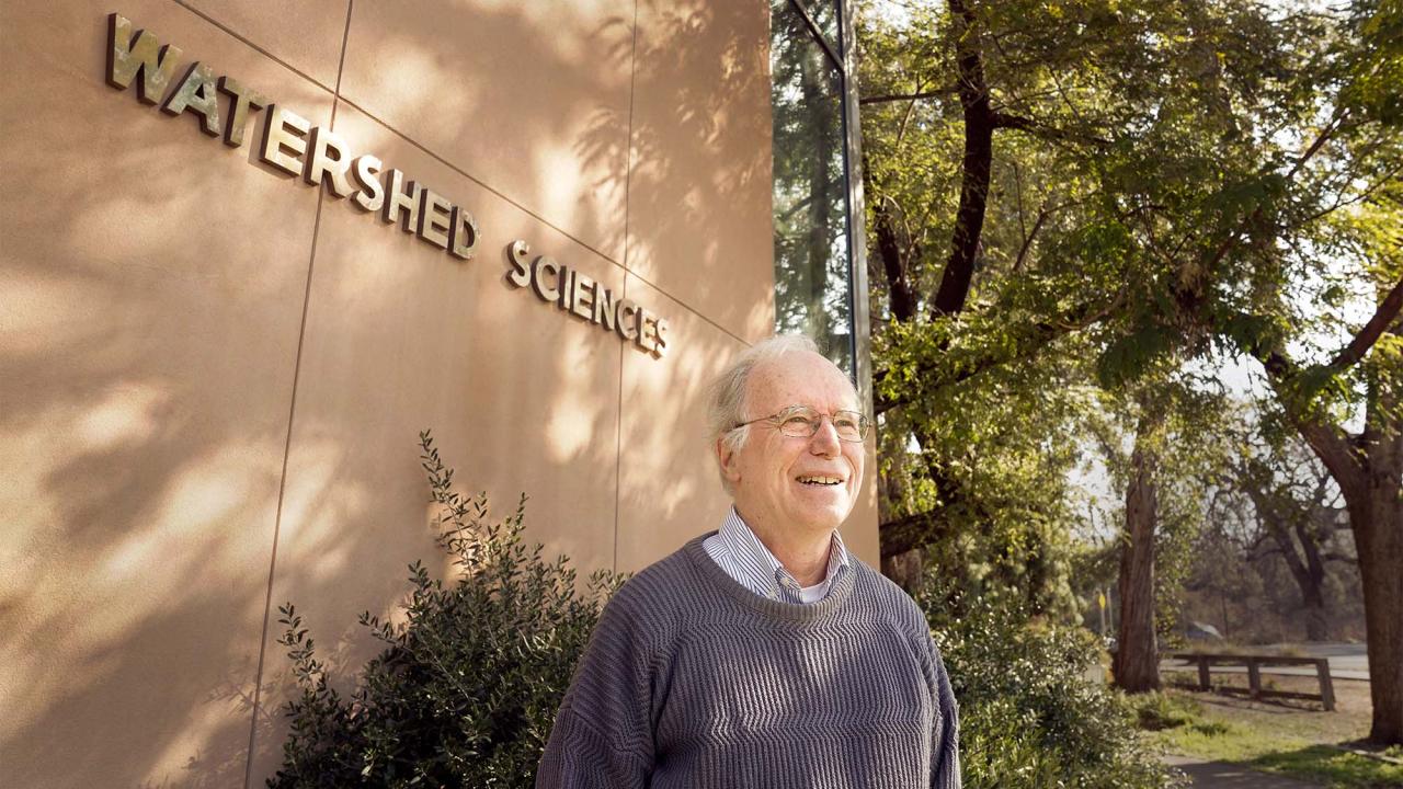 Jay Lund stands in front of sign for Watershed Sciences