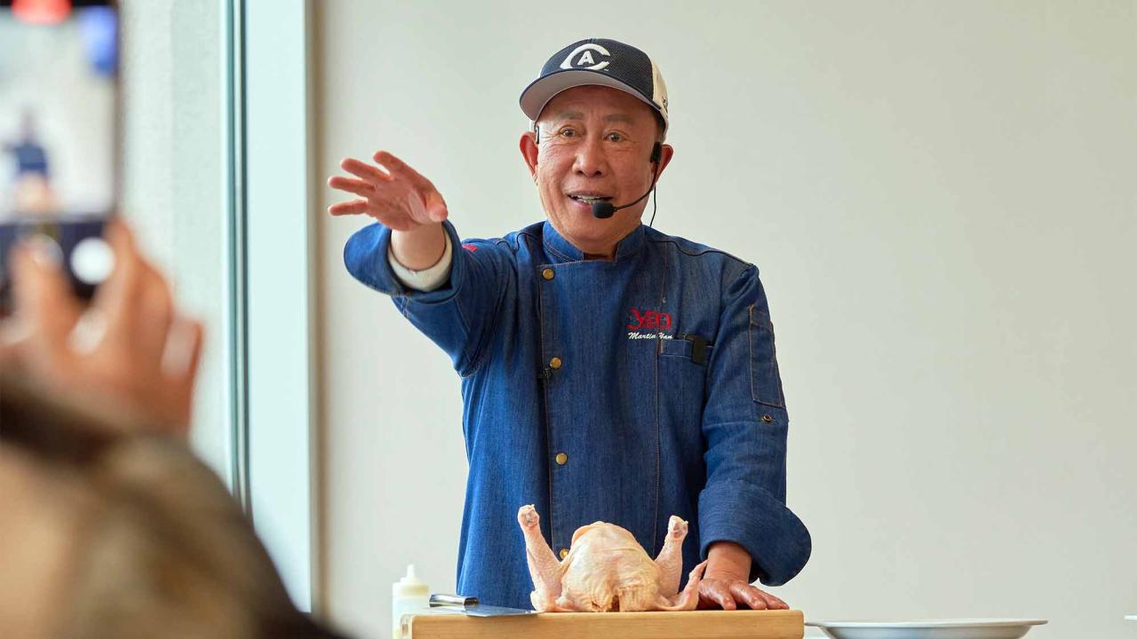 Martin Yan gestures during a cooking demo