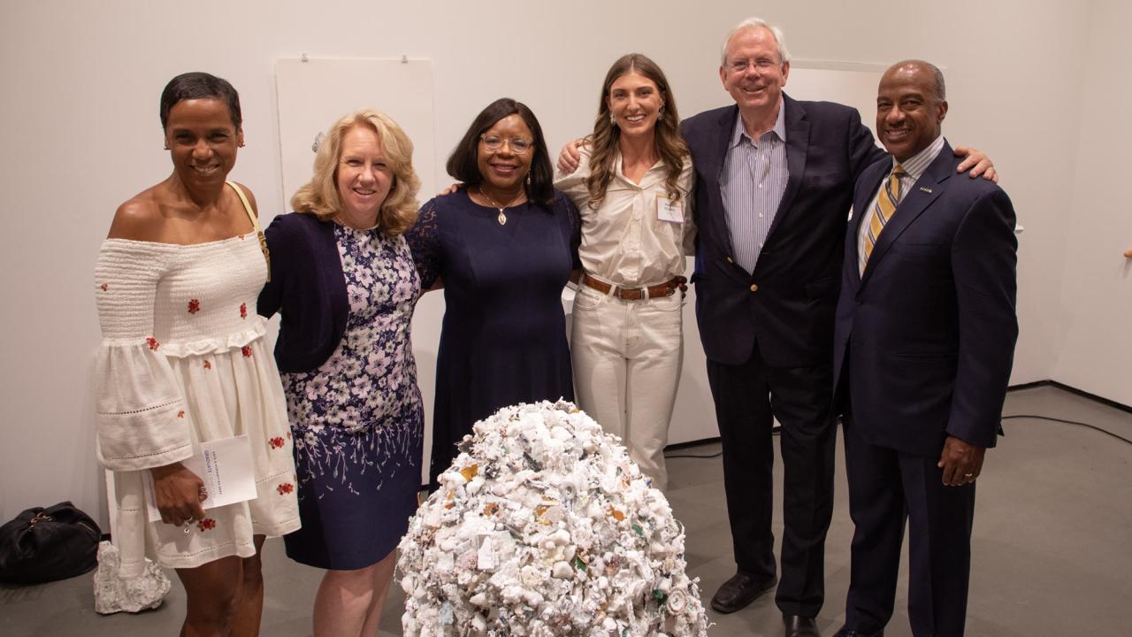 Group of people surrounding artwork