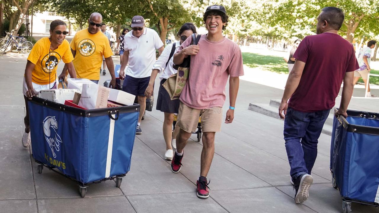 LeShelle May and Gary S. May push a cart filled with a student's belongings during Moove-In.