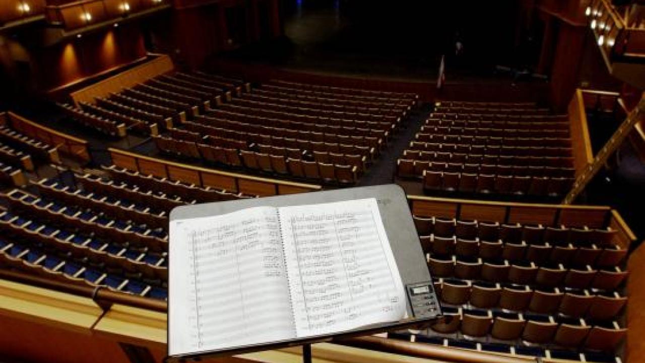 Sheet music rests against a stand in front of several rows of seats facing the stage at the Mondavi Center.