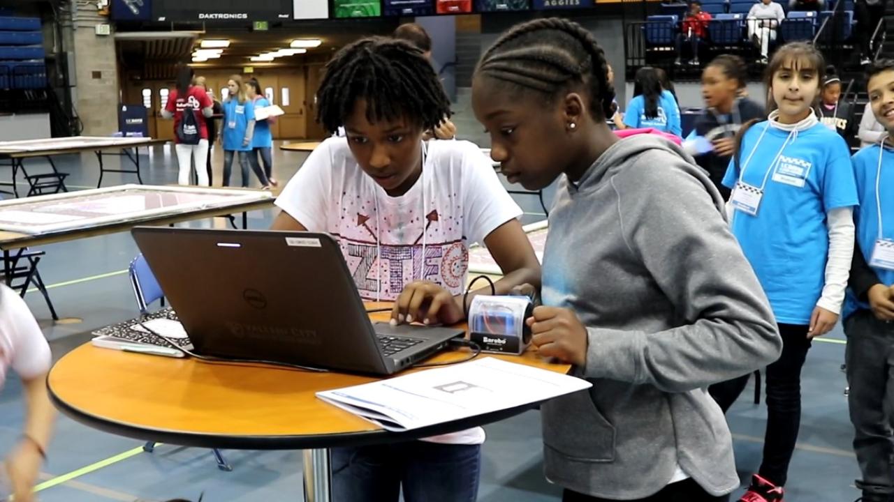 Two girls working at a laptop. 