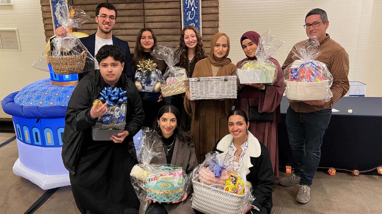 Group of people pose for photo holding gift baskets.