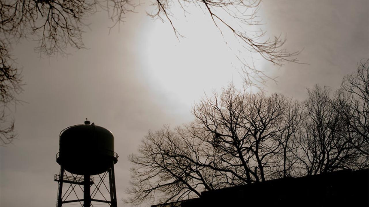 Silhouette of UC Davis Water Tower with sun shining in the background