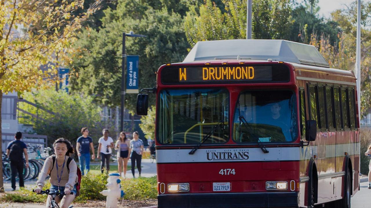 A bus drives down a road surrounded by bicycles