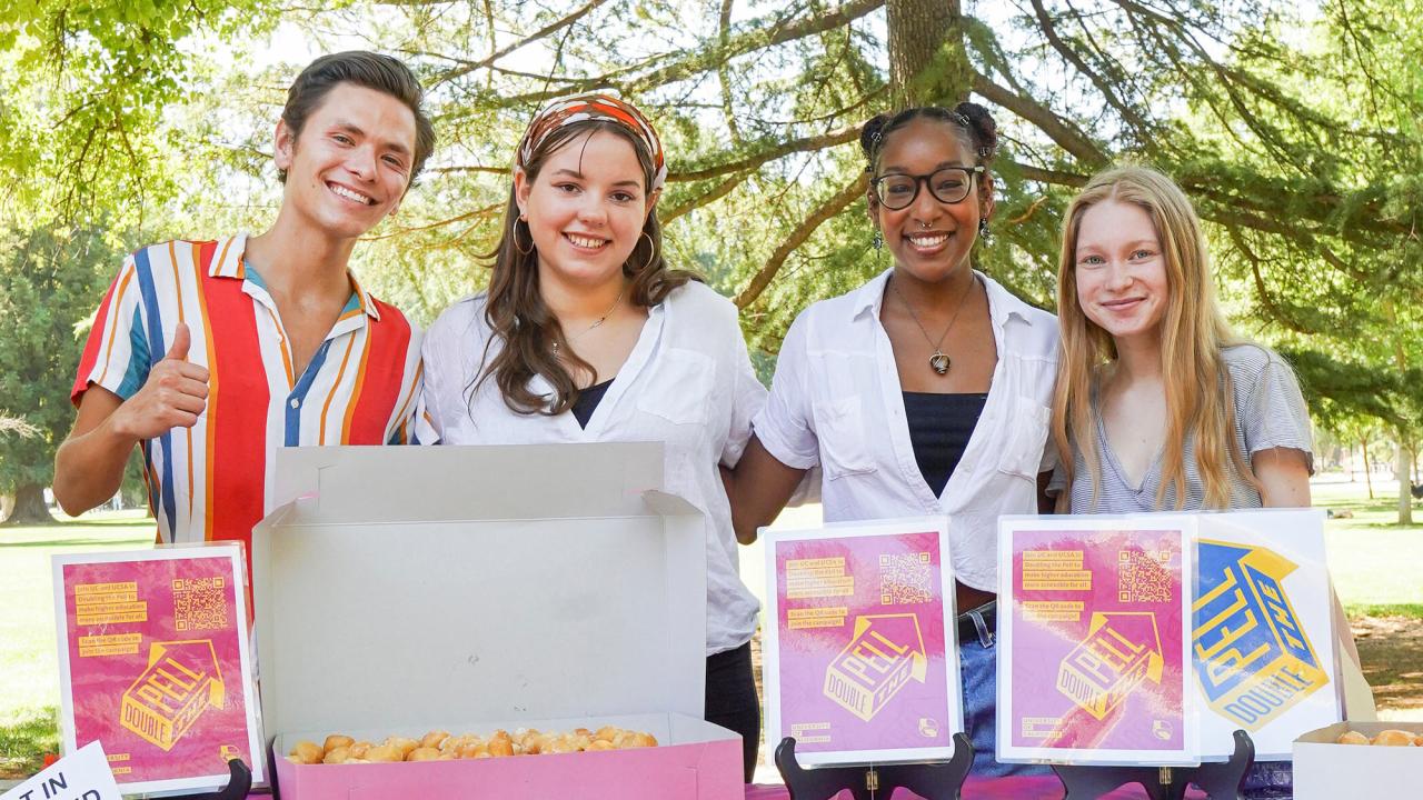 Four students, posed, tabling at the Memorial Union