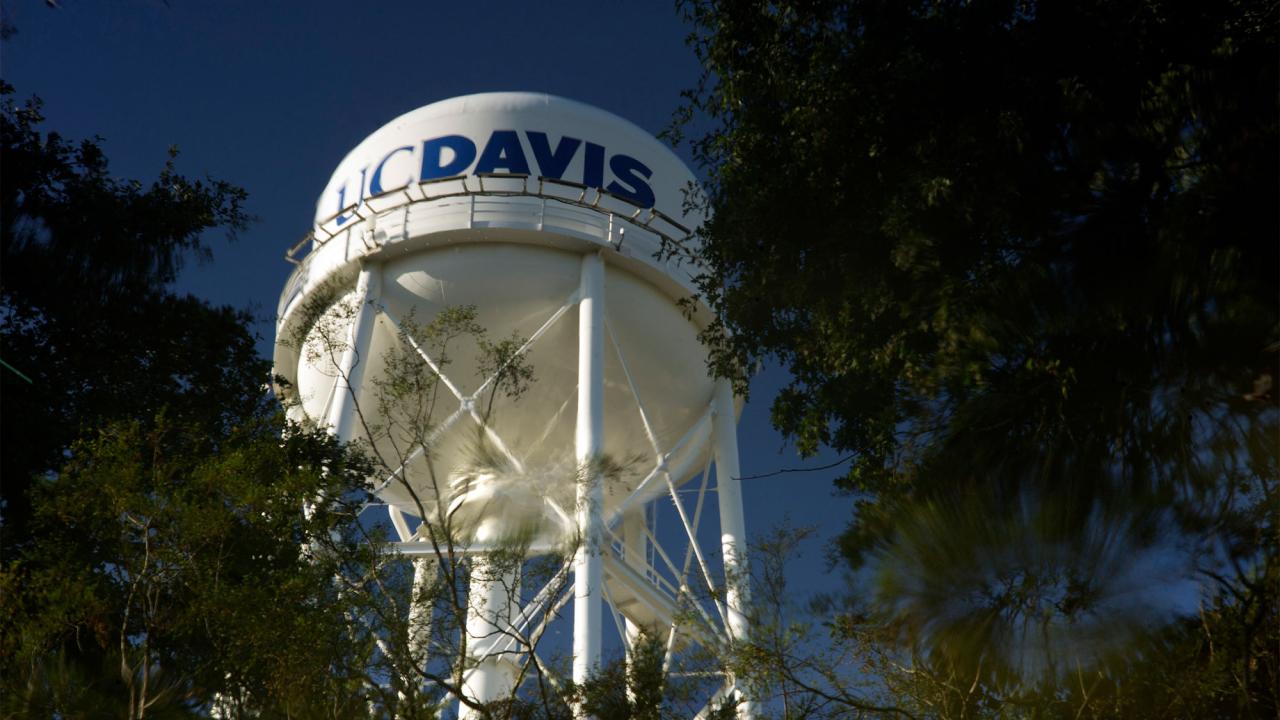 UC Davis water tower with tree greenery foreground