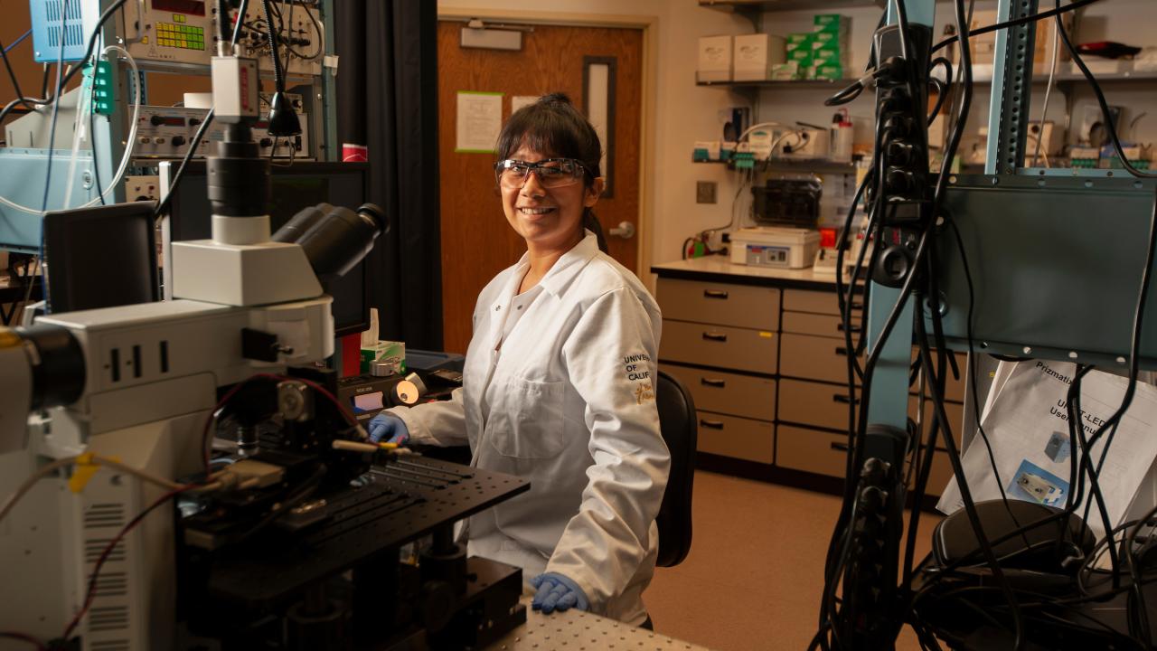 A student smiles in the lab. 