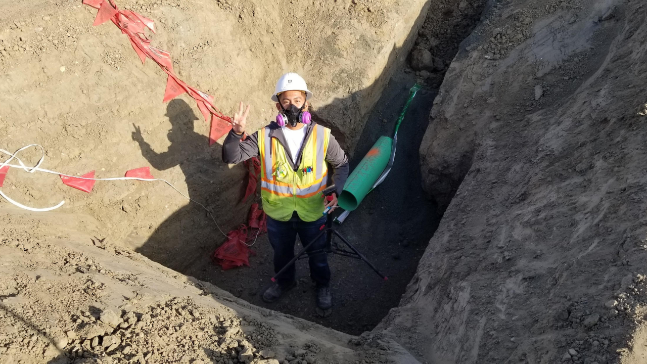 A student in a mask stands in a ditch.