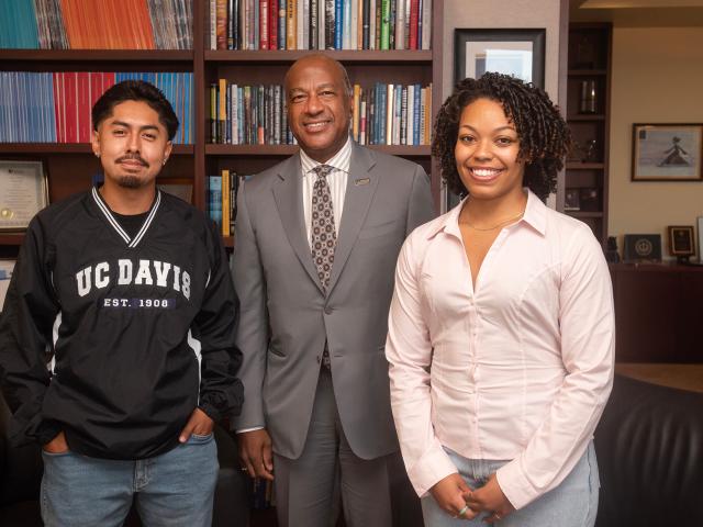 Three people stand in an office