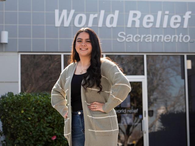 Female student stands in front of World Relief offices