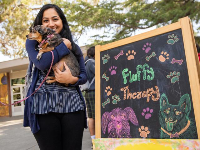 A student holds a puppy at the UCD memorial union