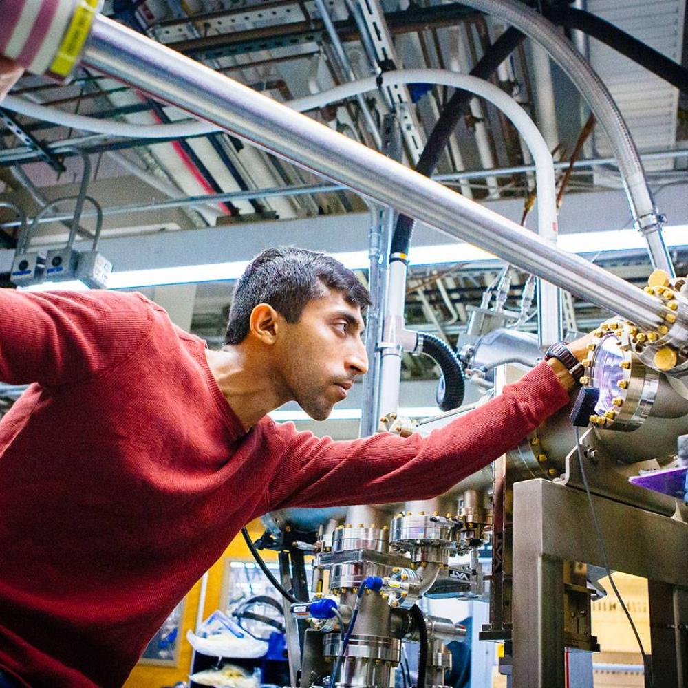 A researcher adjusts some lab machinery