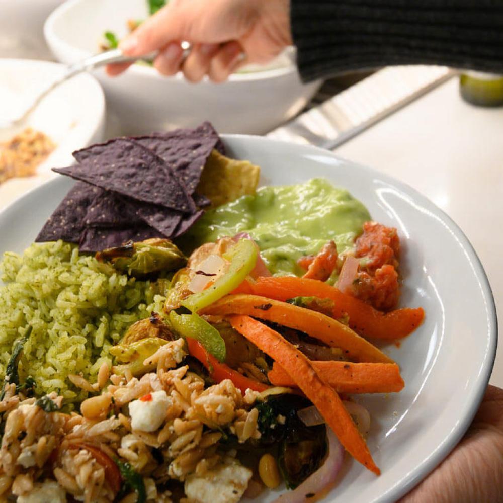 A student loads their plate with delicious food