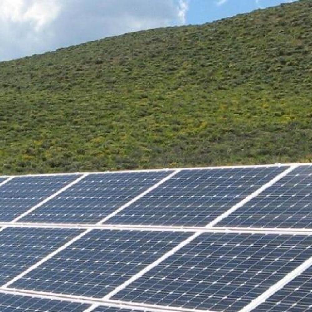 solar panels near hill with trees