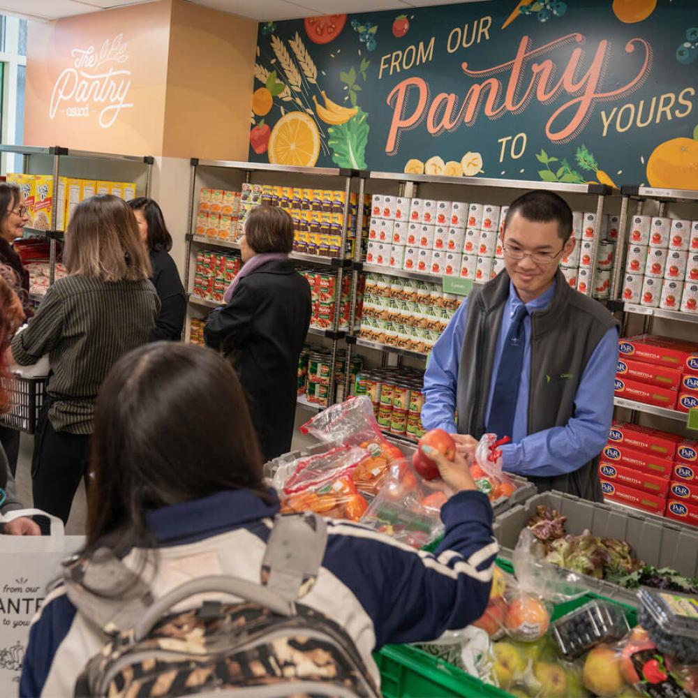 A student helps pass out food to theif fekllow students