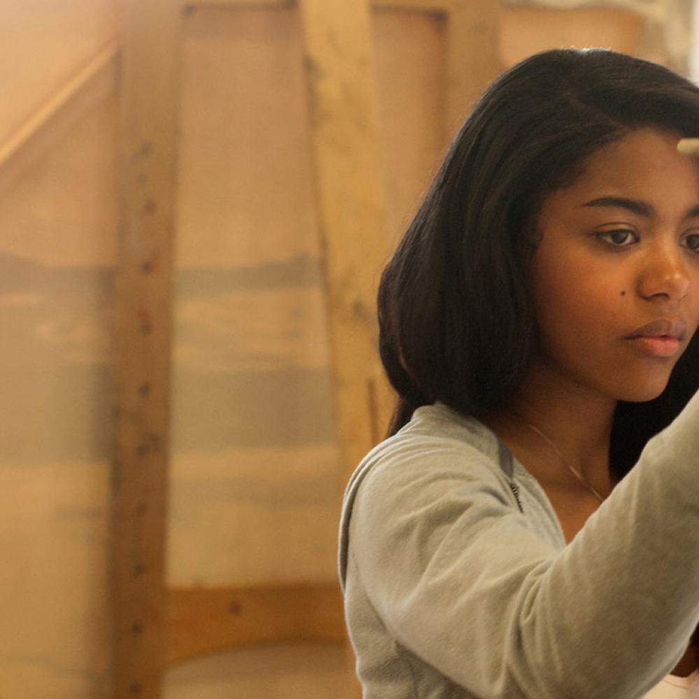 A female student painting on a canvas