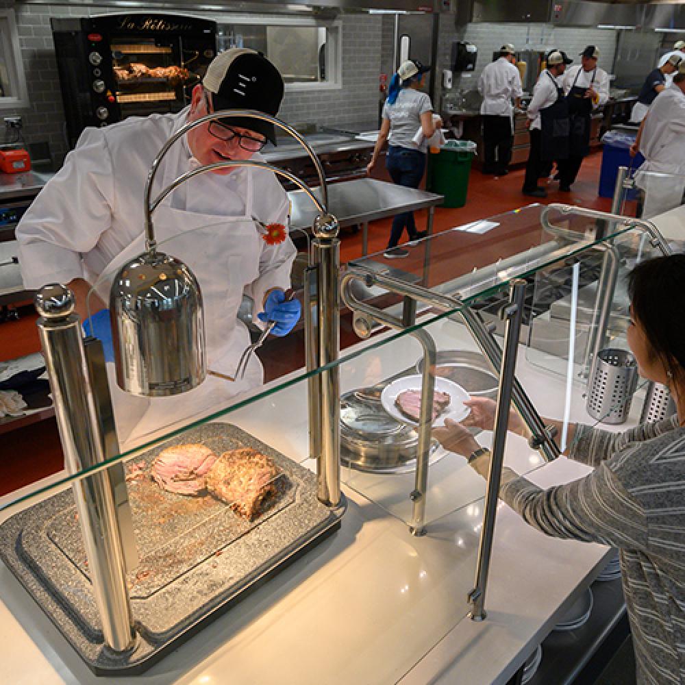 student watches on as food is prepared for her in uc davis dining commons